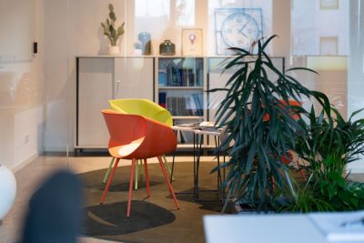 Empfangslösung mit bunten Armlehnstühlen, Beistelltisch und Stauraum