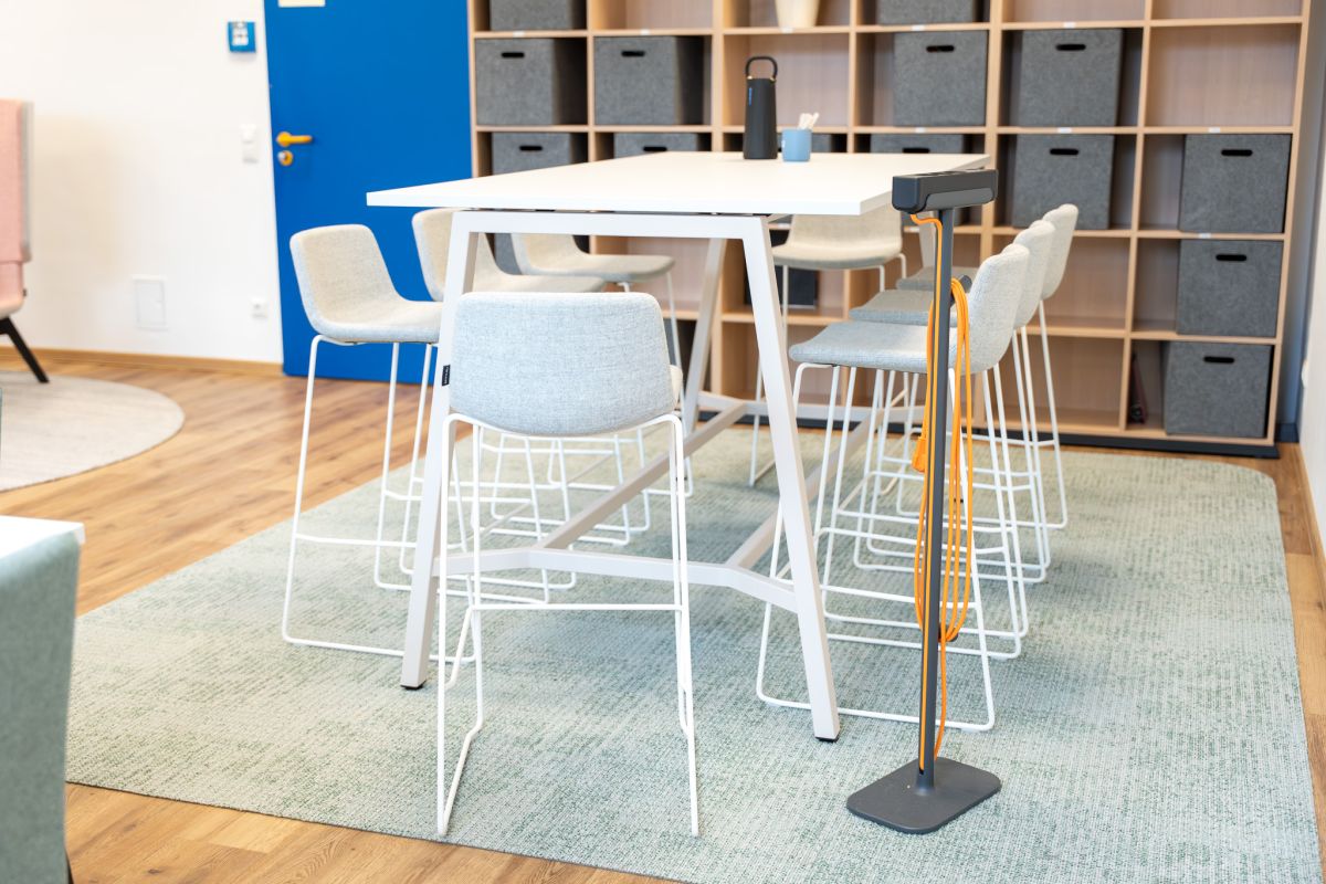 Hochtisch-Settings und flexible Sitzmöglichkeiten unterstützen spontane Gespräche und gemeinsames Miteinander