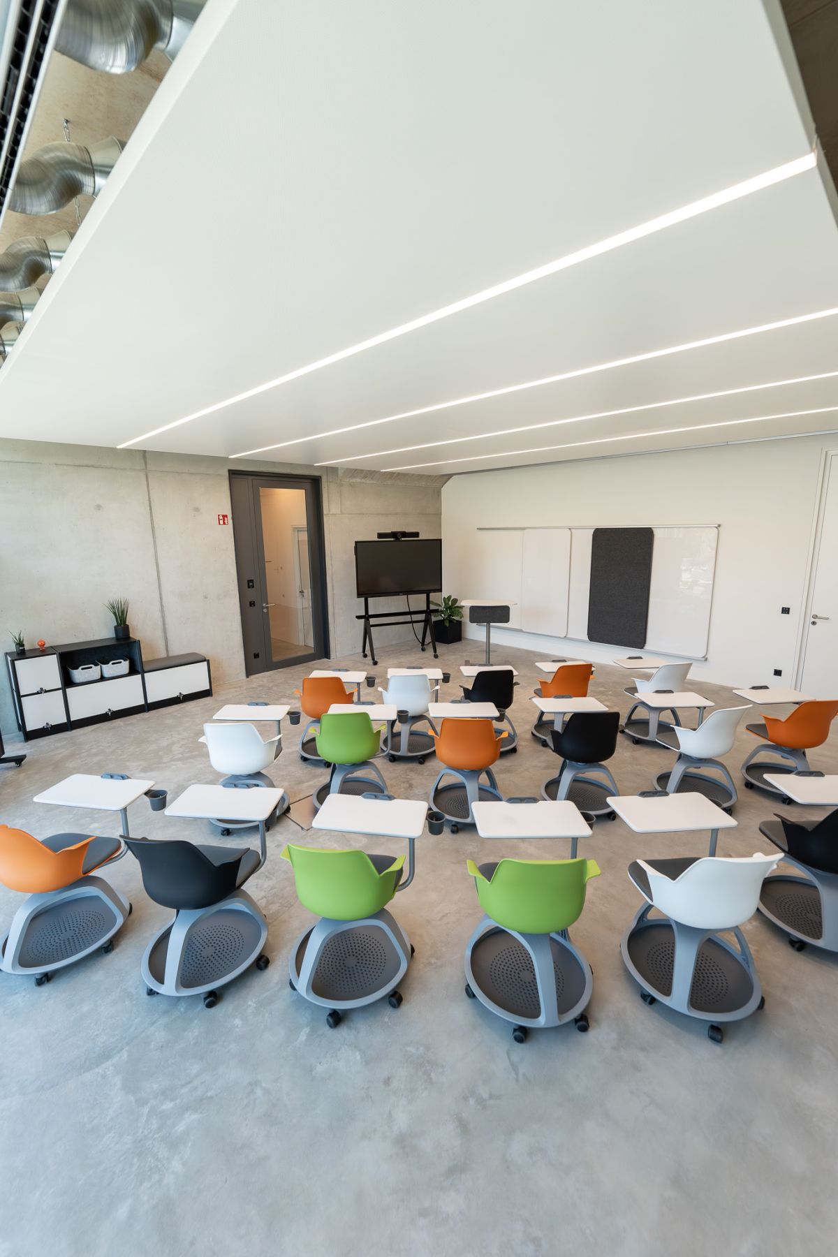 Hochmoderner, anpassungsfähiger Schulungsraum mit beweglichen Tablaren an den rollbaren Seminarstühlen