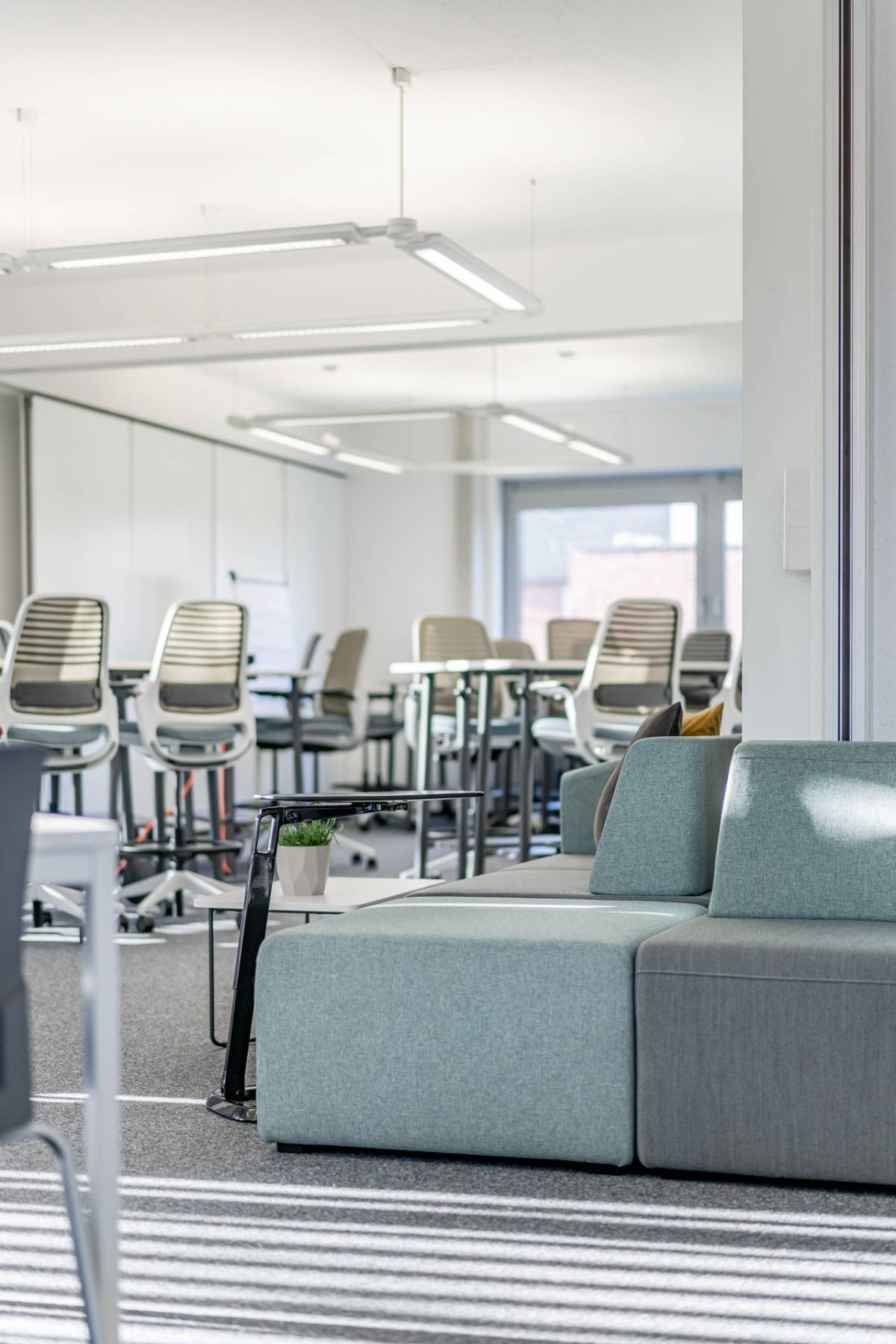 Hochtischlösung mit Counterstühle für den Lernbereich kombiniert mit einem Sofa für den Loungebereich